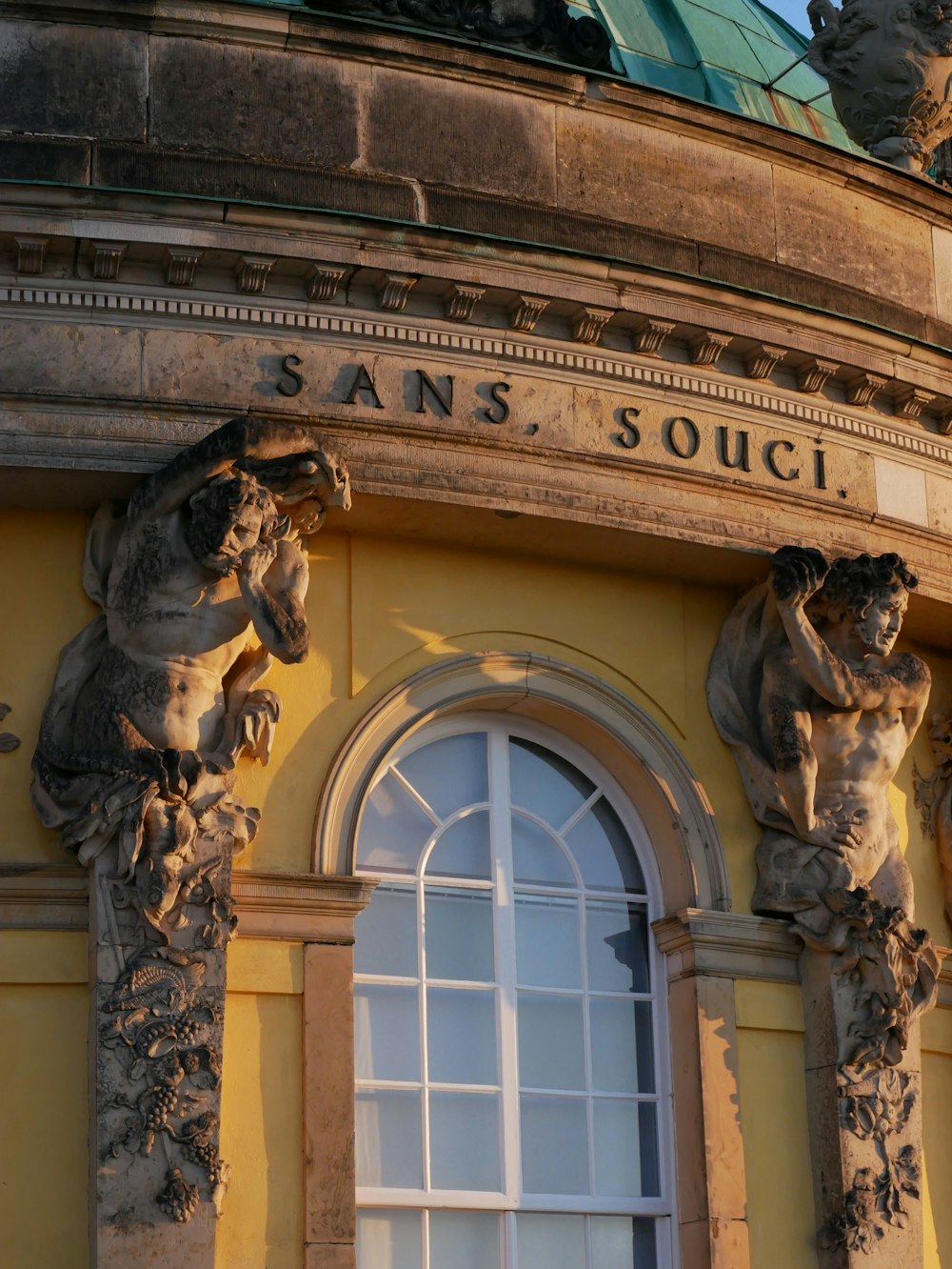 gold lion statue in front of white concrete building