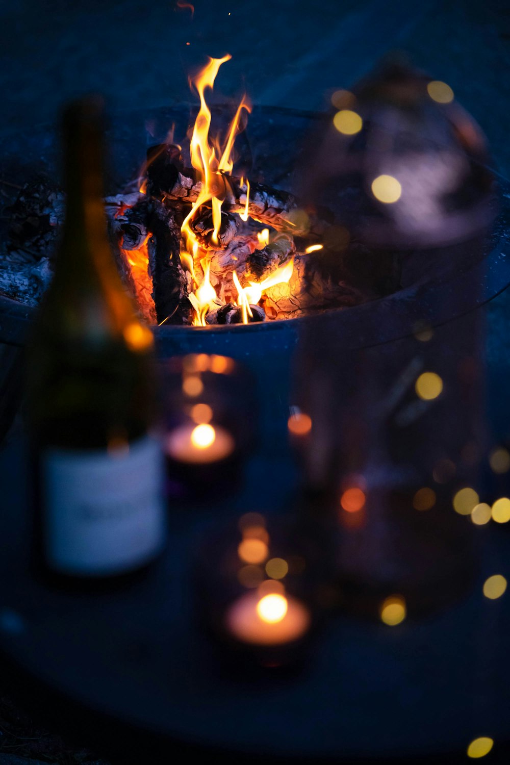 a bottle of wine sitting next to a fire