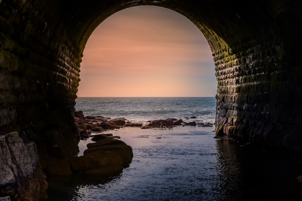 brown arch on sea shore during daytime