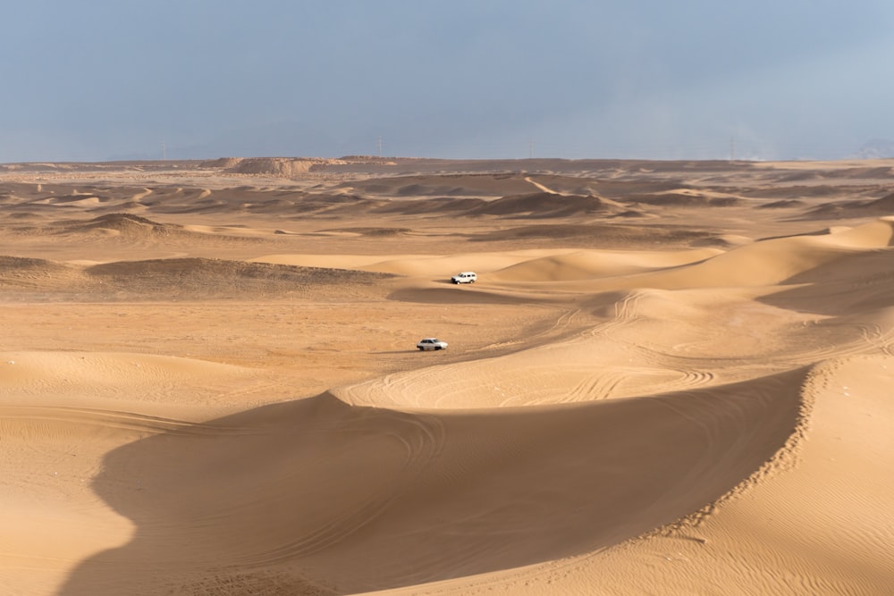 person in black shirt walking on desert during daytime
