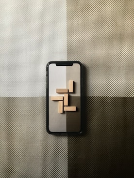 black iphone case on gray textile