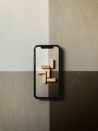black iphone case on gray textile