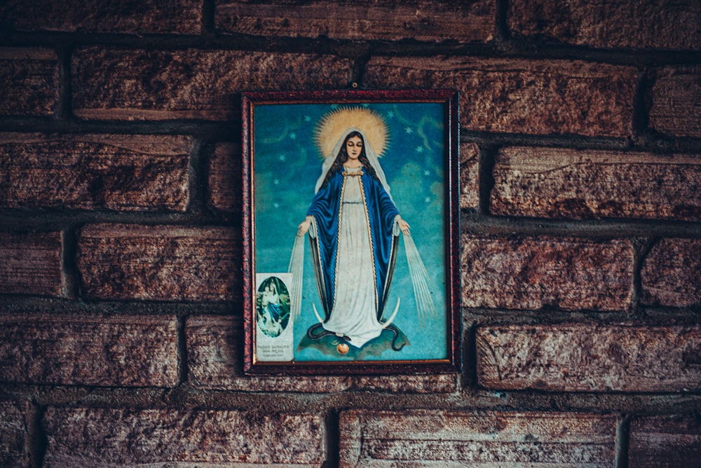 a picture of the virgin mary on a brick wall