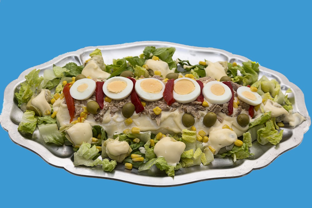 a platter of salad with hard boiled eggs on top