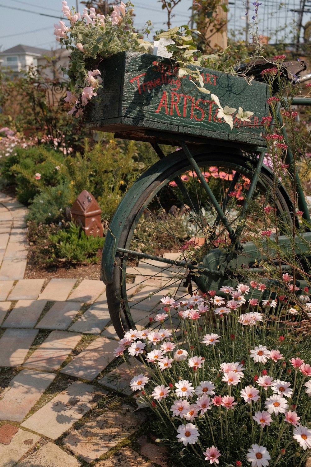 a green bicycle with flowers growing out of it