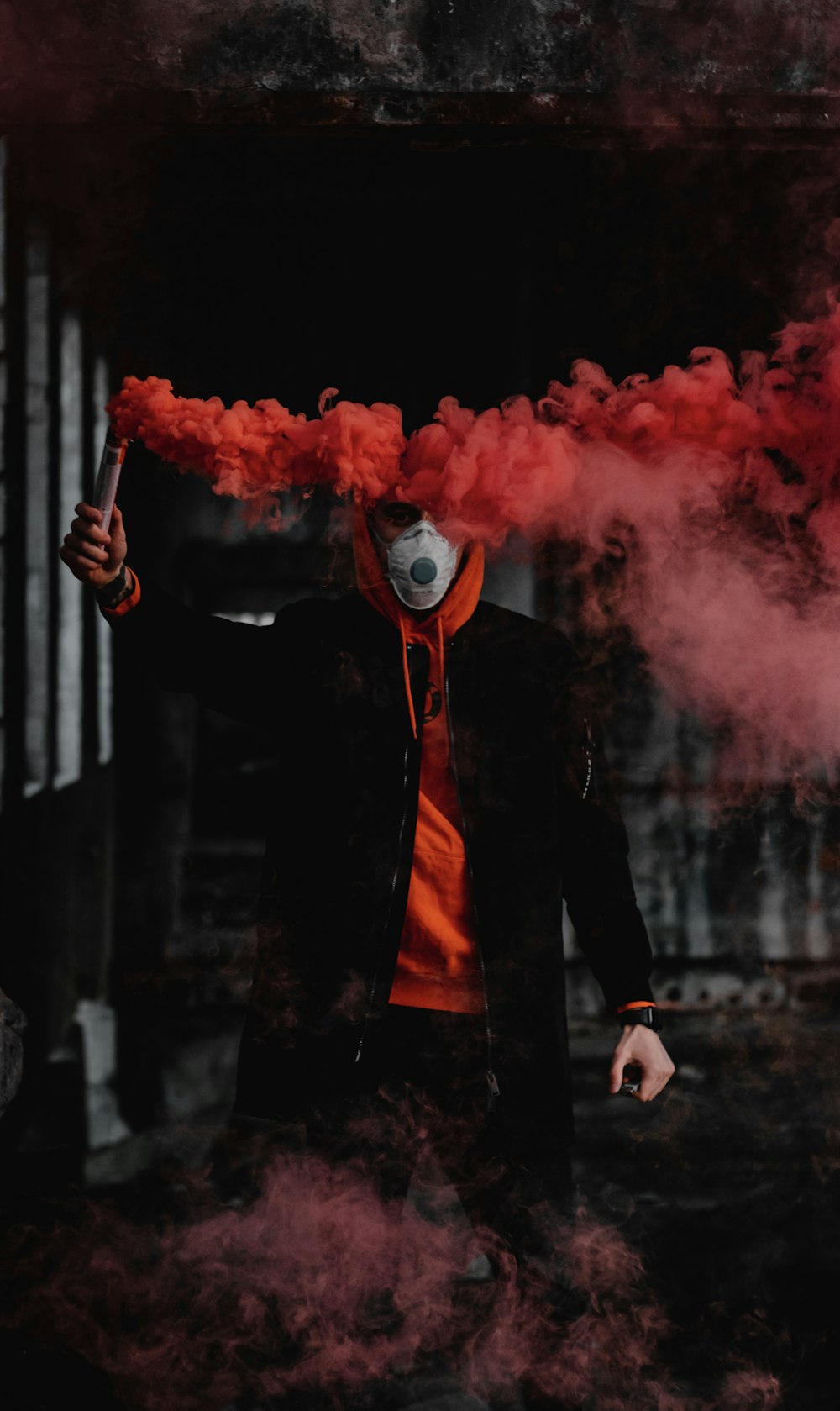 man in black suit holding red smoke