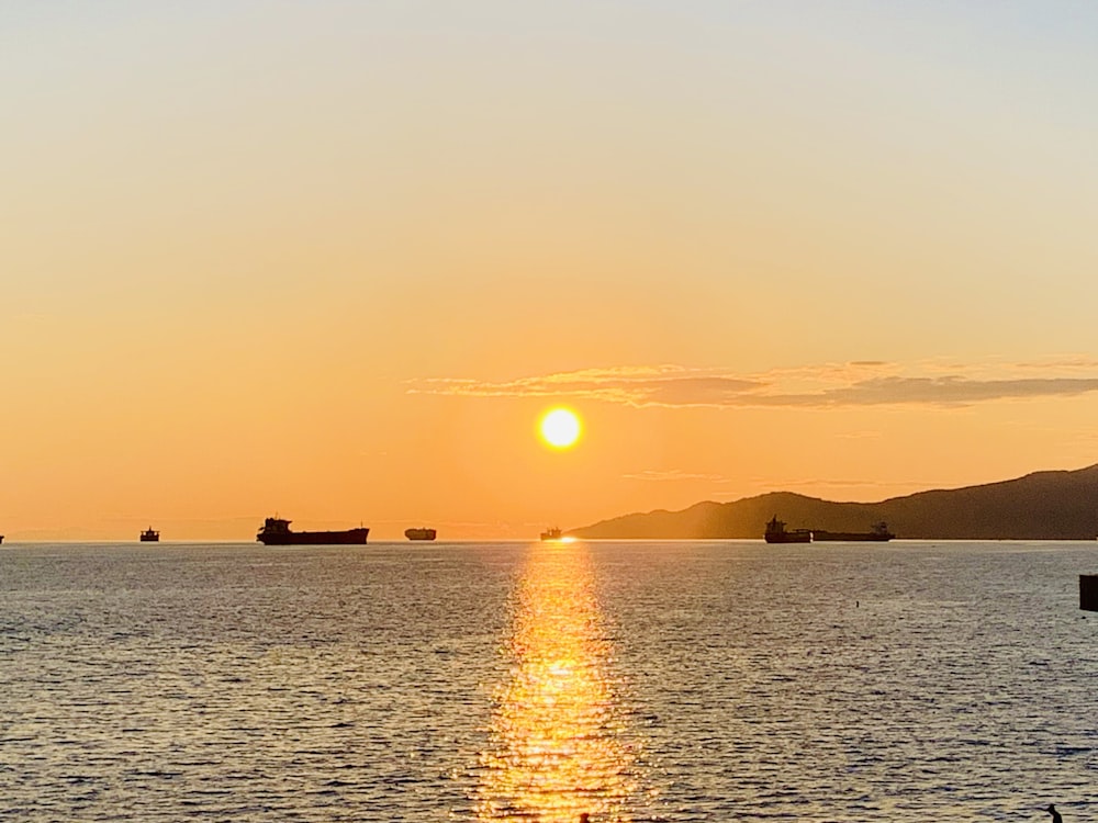 silhouette of boat on sea during sunset