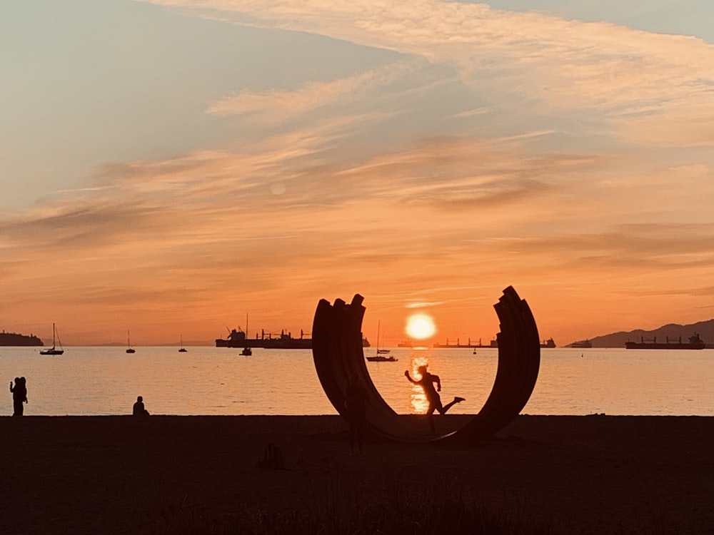 people standing on beach during sunset