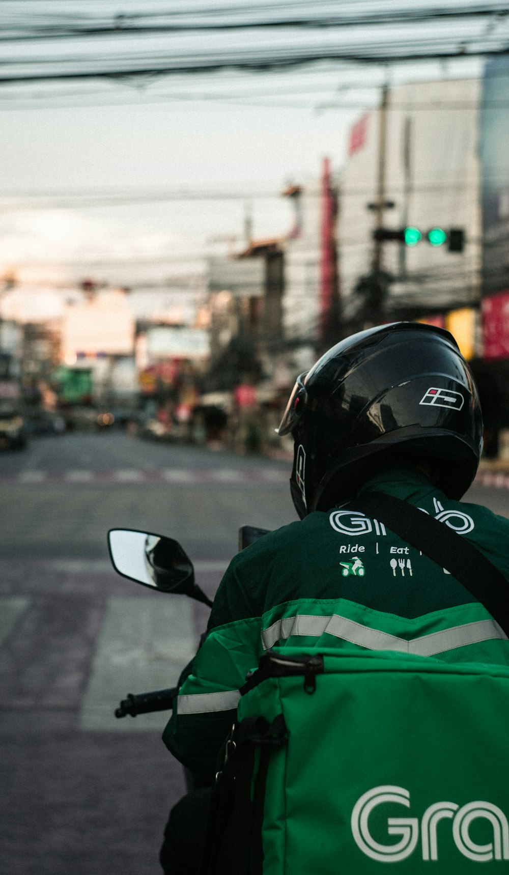 Homme en veste verte et noire portant un casque noir