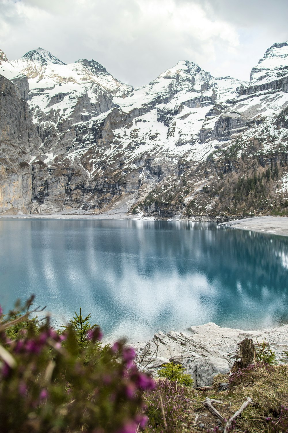 lago azul entre montanhas rochosas cinzentas durante o dia