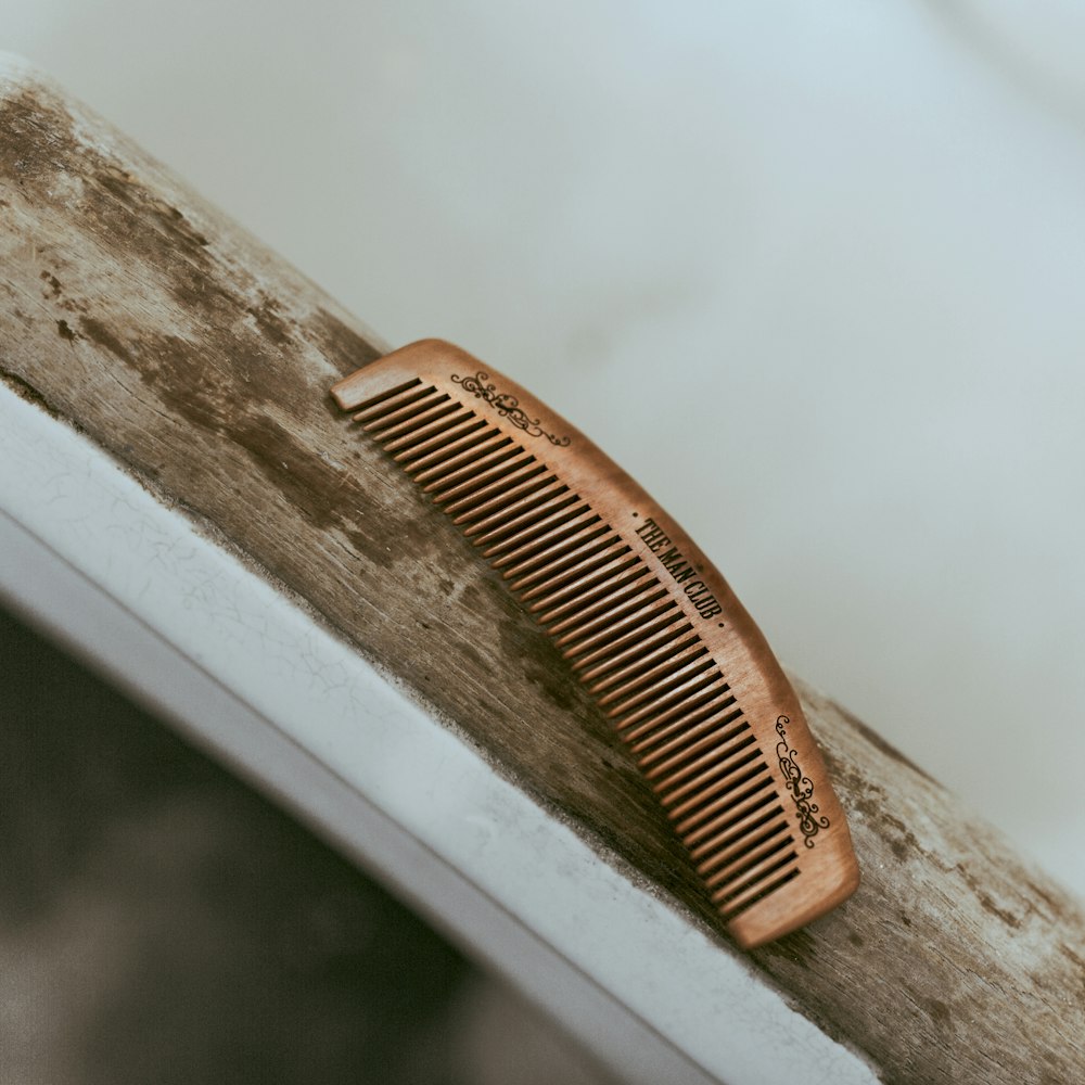 pettine per capelli castani su tavolo di legno bianco