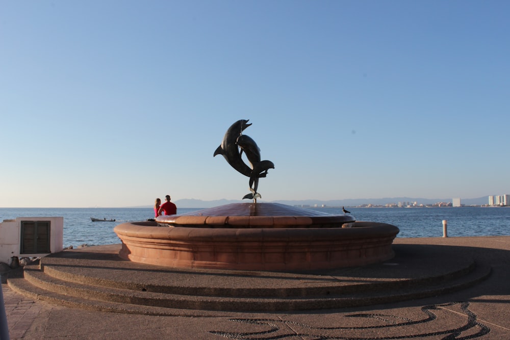 black bird statue on brown concrete fountain during daytime