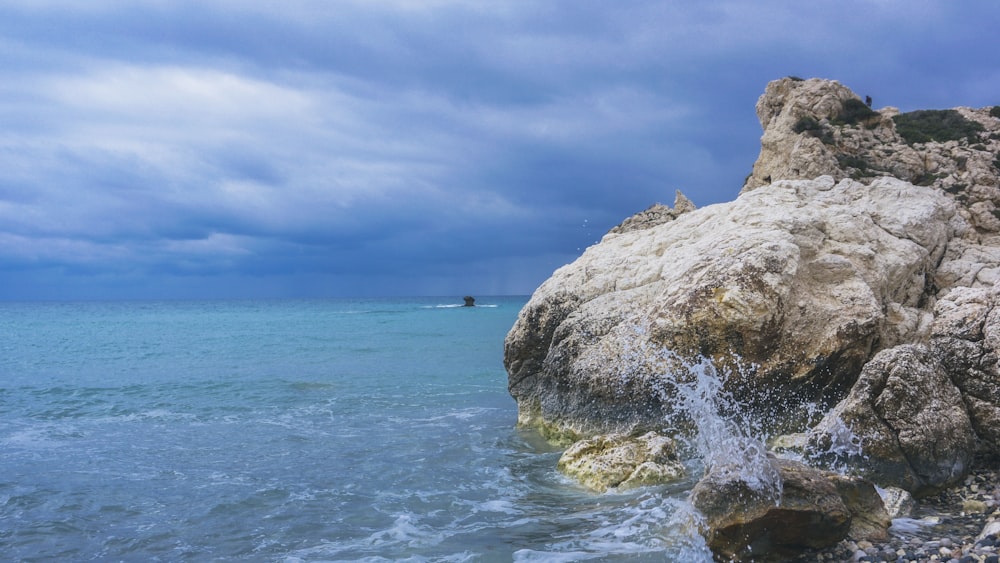 brown rock formation near body of water during daytime