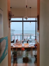 A cozy writer's desk with historical books and a quill pen by a window overlooking the Baltic Sea coast.