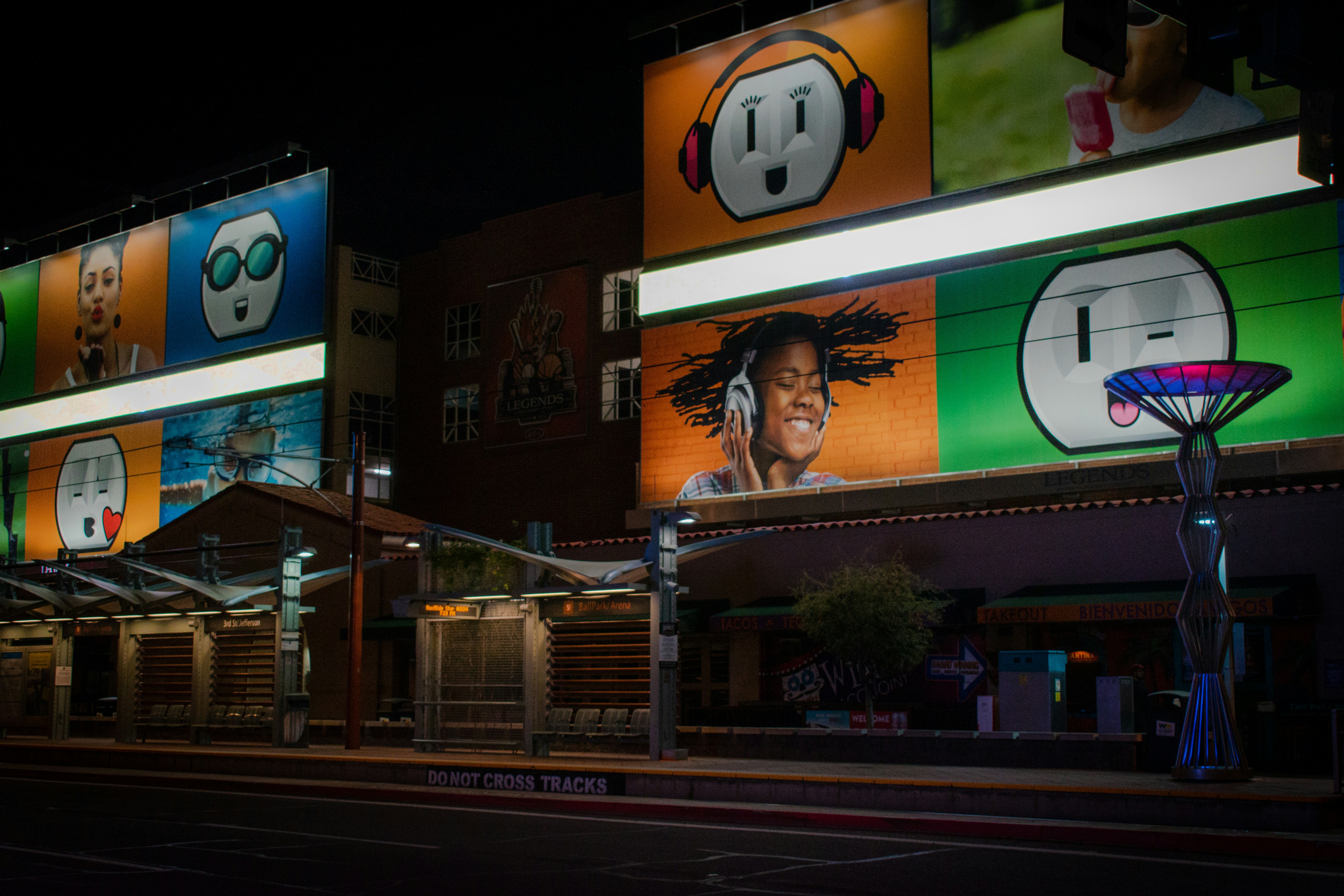 woman in black shirt standing beside black metal fence during night time