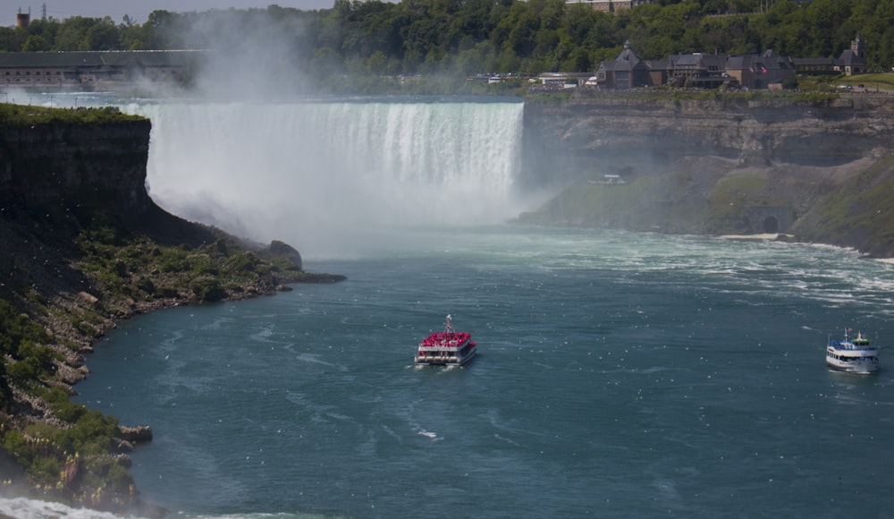 red boat on water falls during daytime