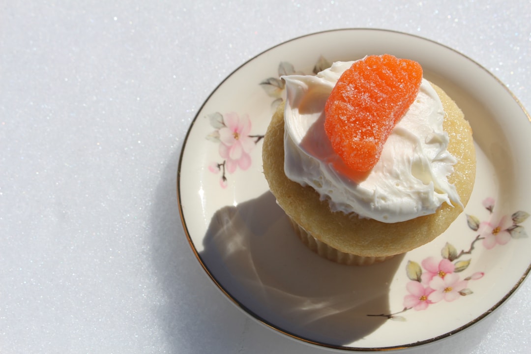 cupcake with orange candy on flower plate
