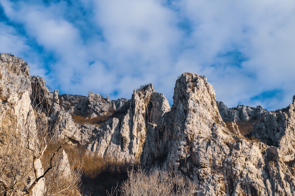 brown rocky mountain under white clouds and blue sky during daytime