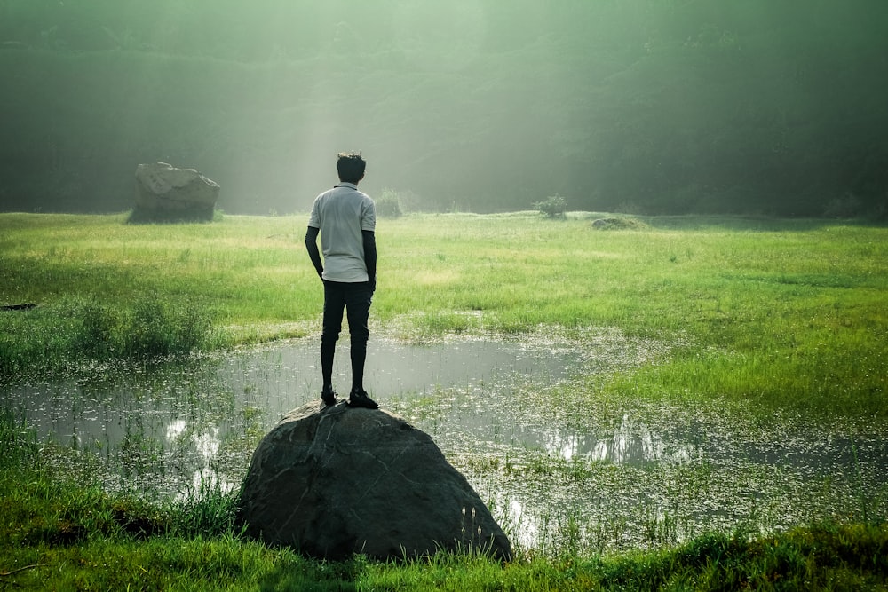 man in white shirt standing on green grass field during daytime