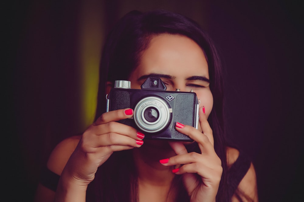 woman holding black and silver camera