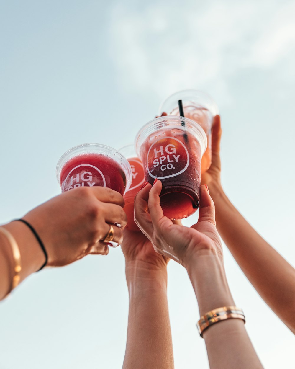 2 person holding red coca cola drinking cups