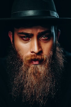 man with black beard wearing black hat