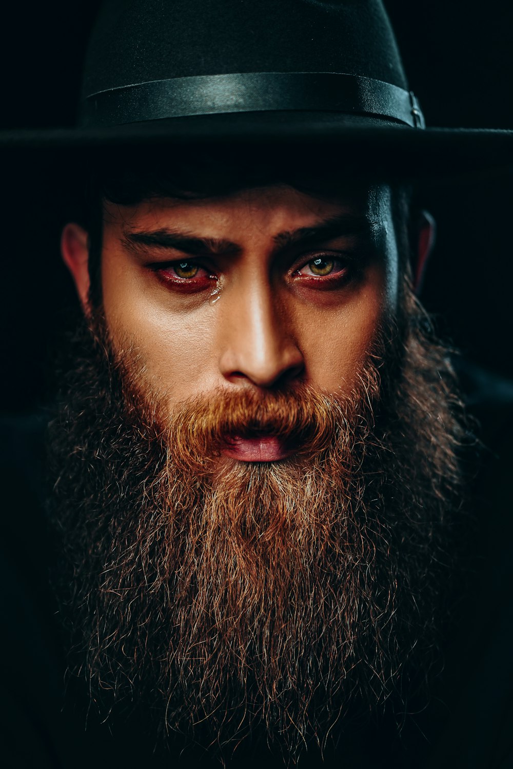 man with black beard wearing black hat