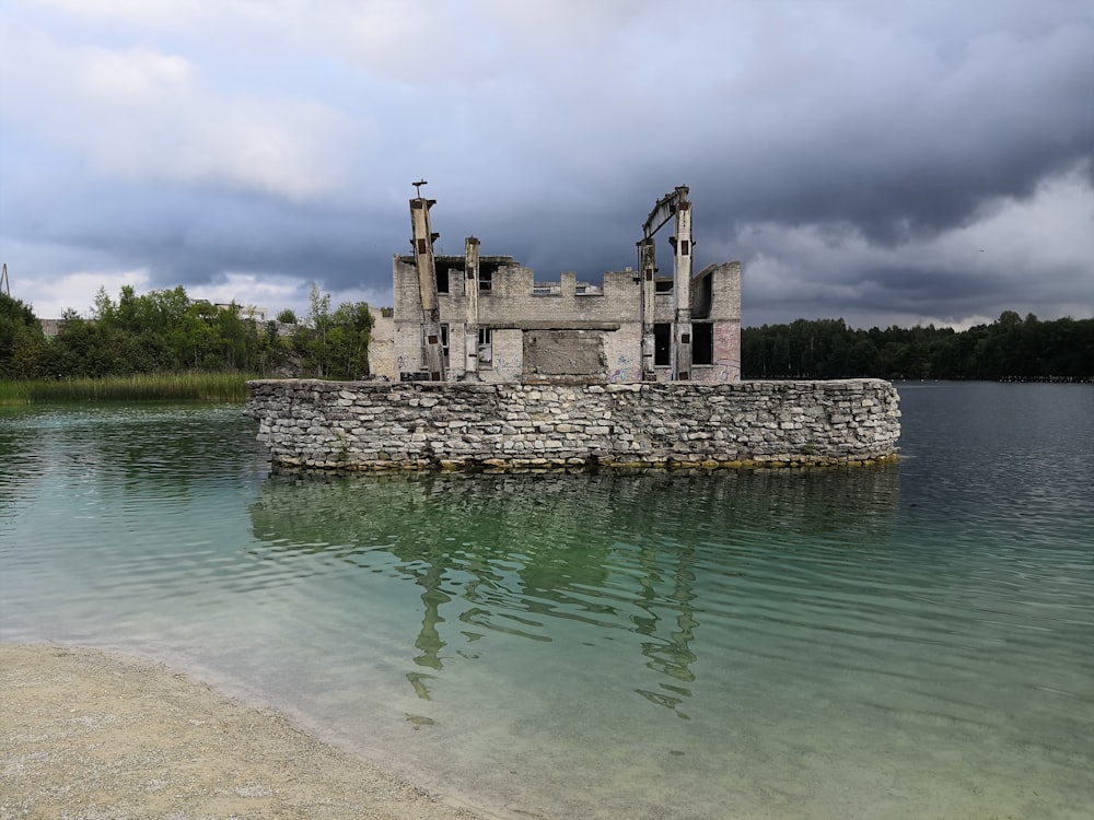 gray concrete building on body of water under cloudy sky during daytime