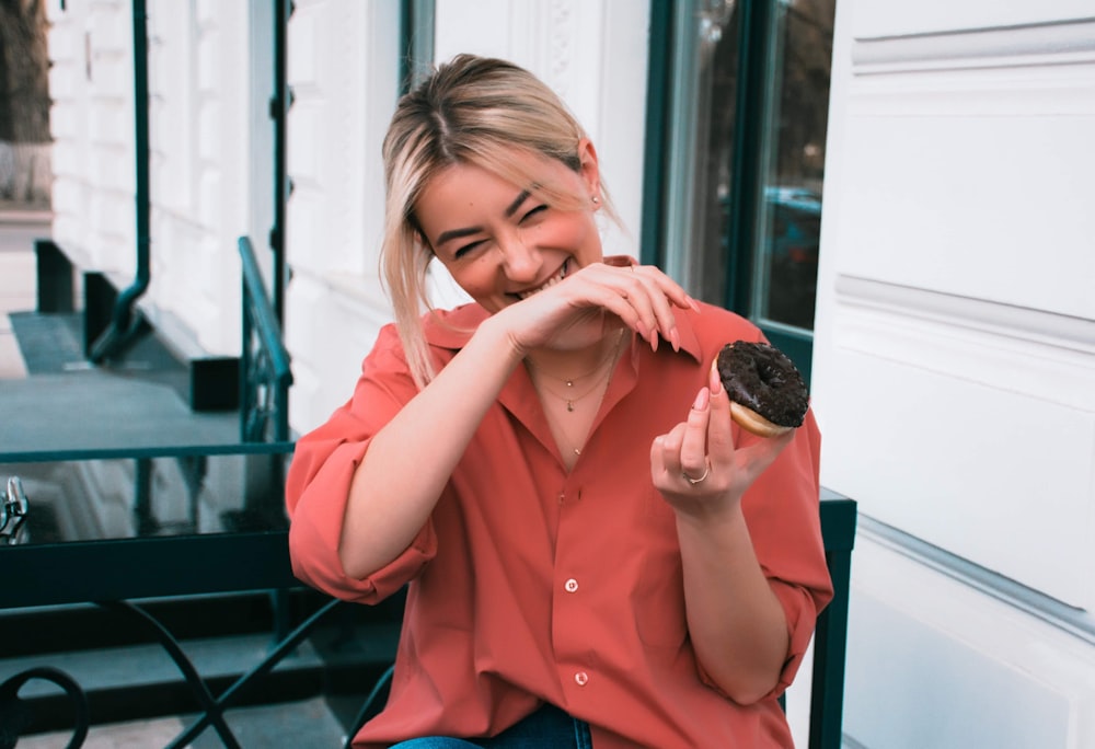 woman in orange button up shirt holding chocolate ice cream