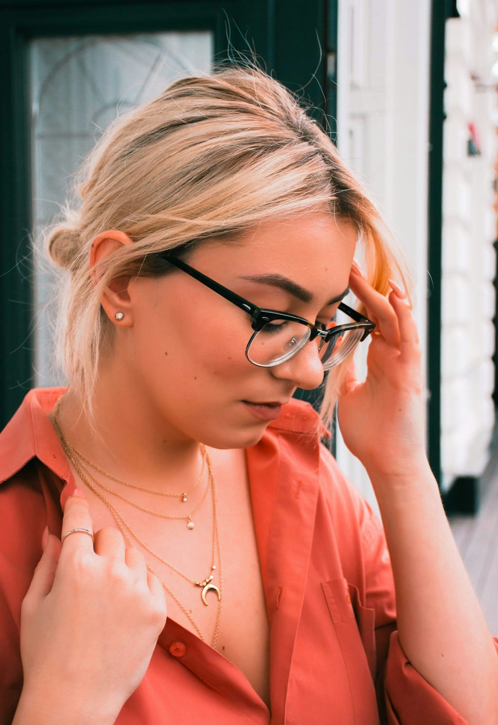 woman in orange shirt wearing black framed eyeglasses