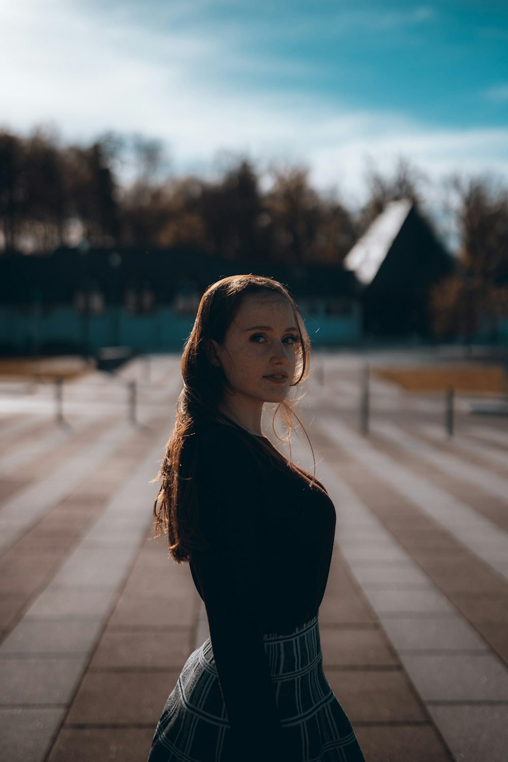 woman in black long sleeve shirt standing on sidewalk during daytime