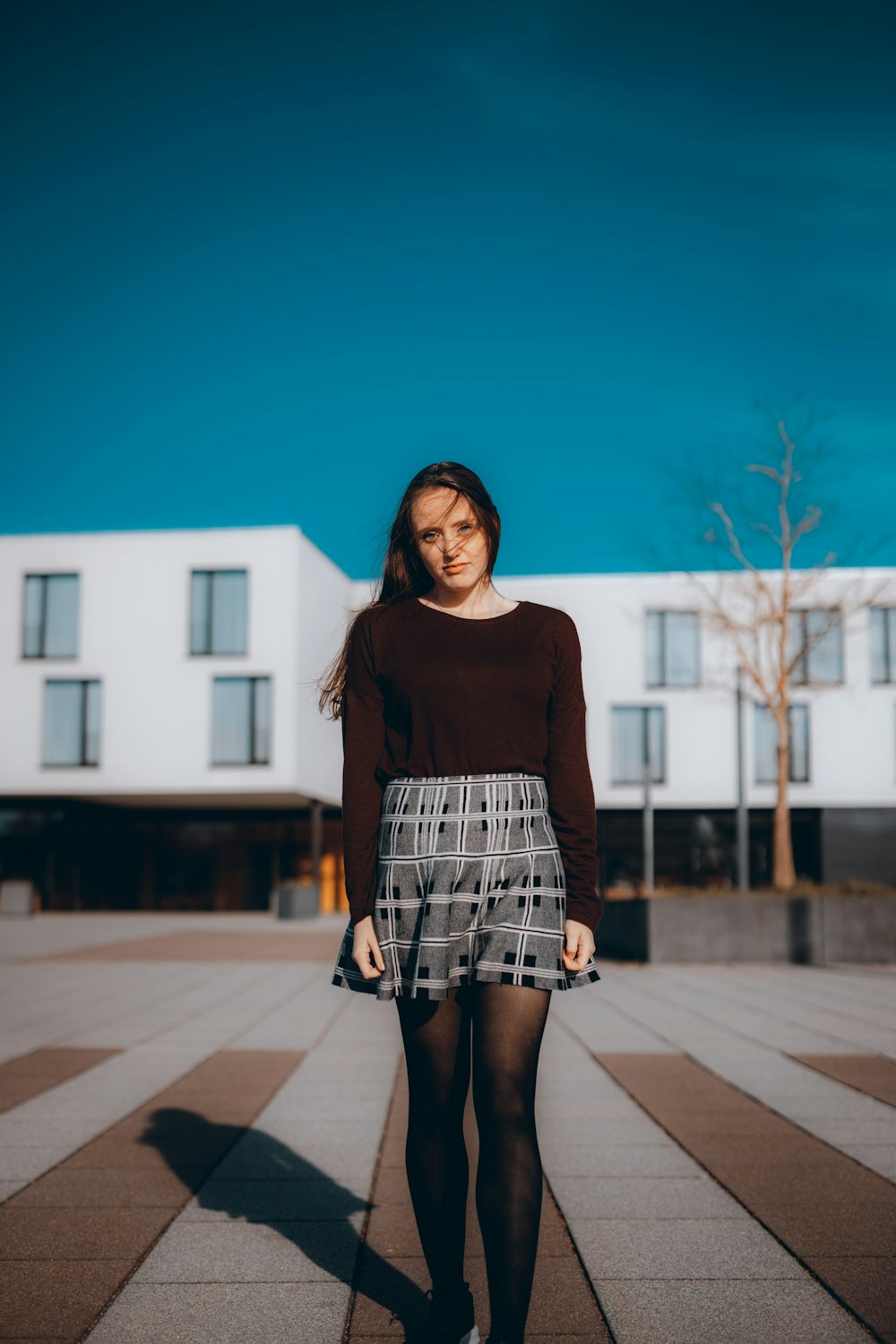 woman in black long sleeve shirt standing on gray concrete pavement during daytime