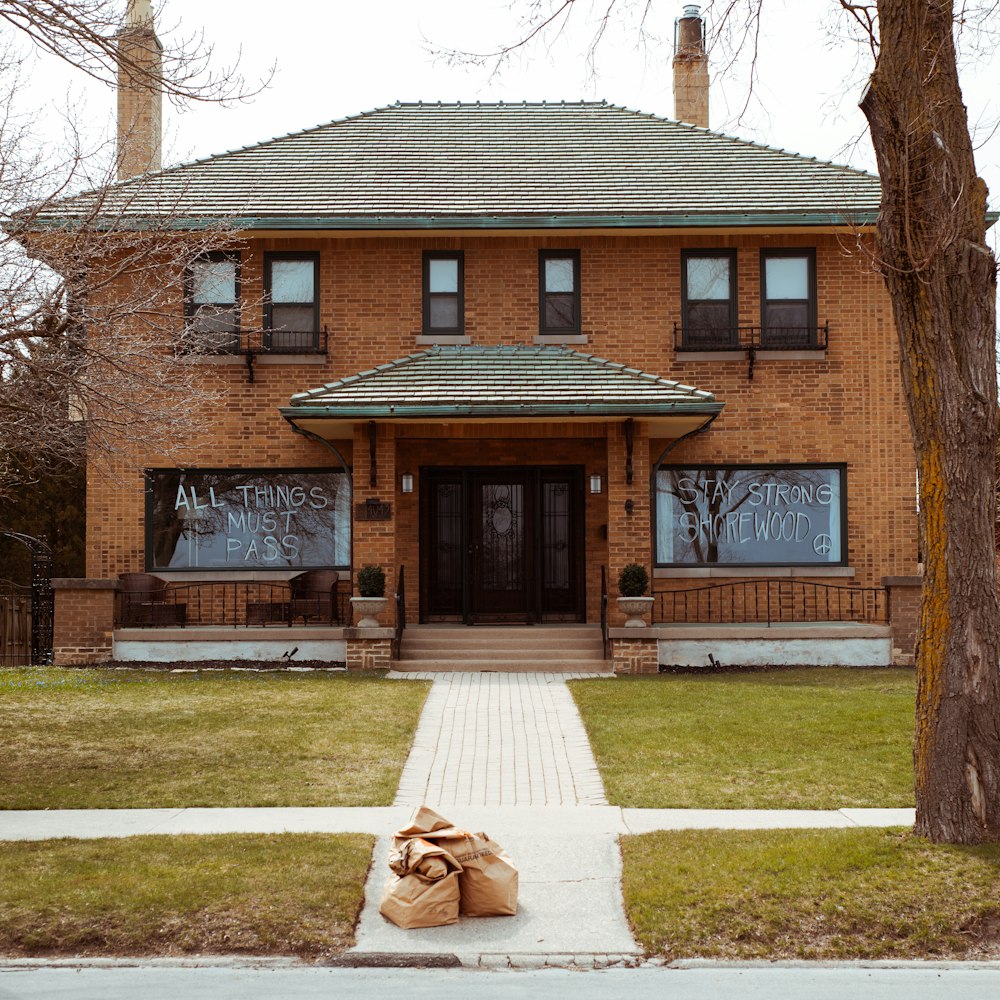 brown brick house near bare trees during daytime