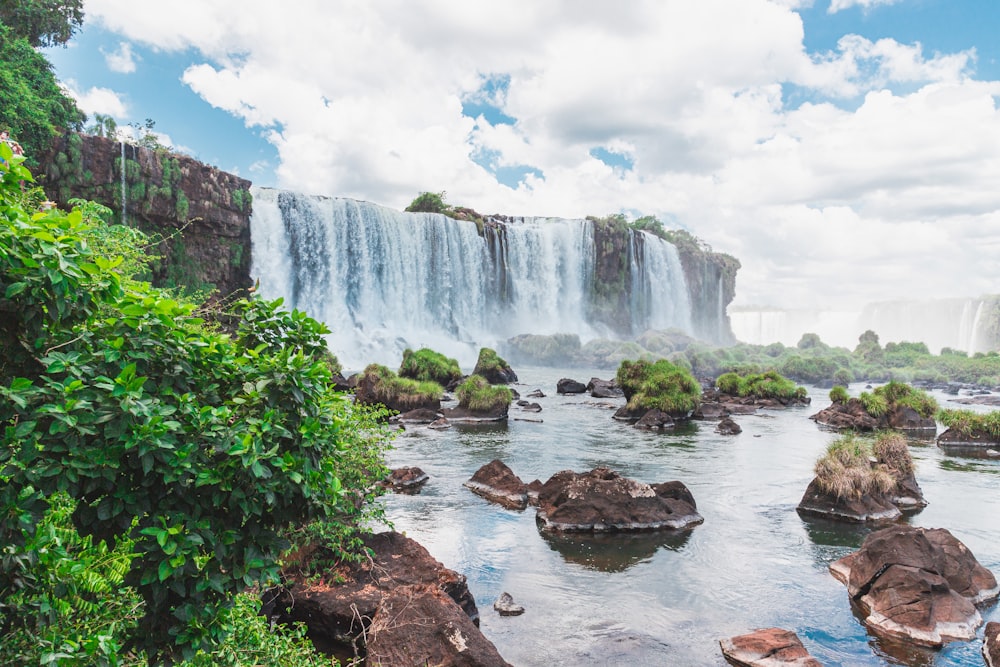 waterfalls under white clouds during daytime