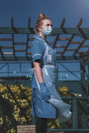 woman in blue and white polo shirt standing on yellow flower field during daytime