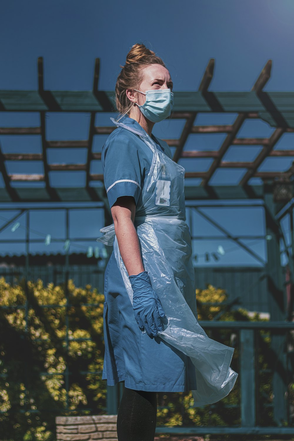 Mujer en polo azul y blanco de pie en el campo de flores amarillas durante el día