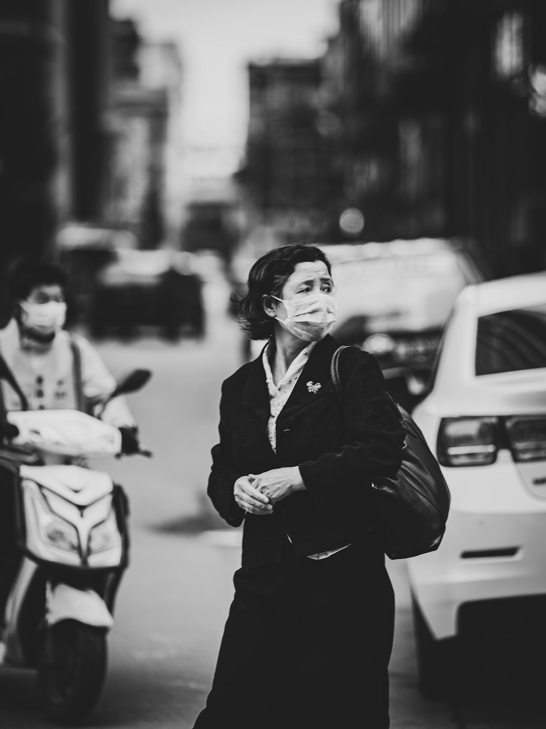 grayscale photo of woman in black coat and black sunglasses holding smartphone