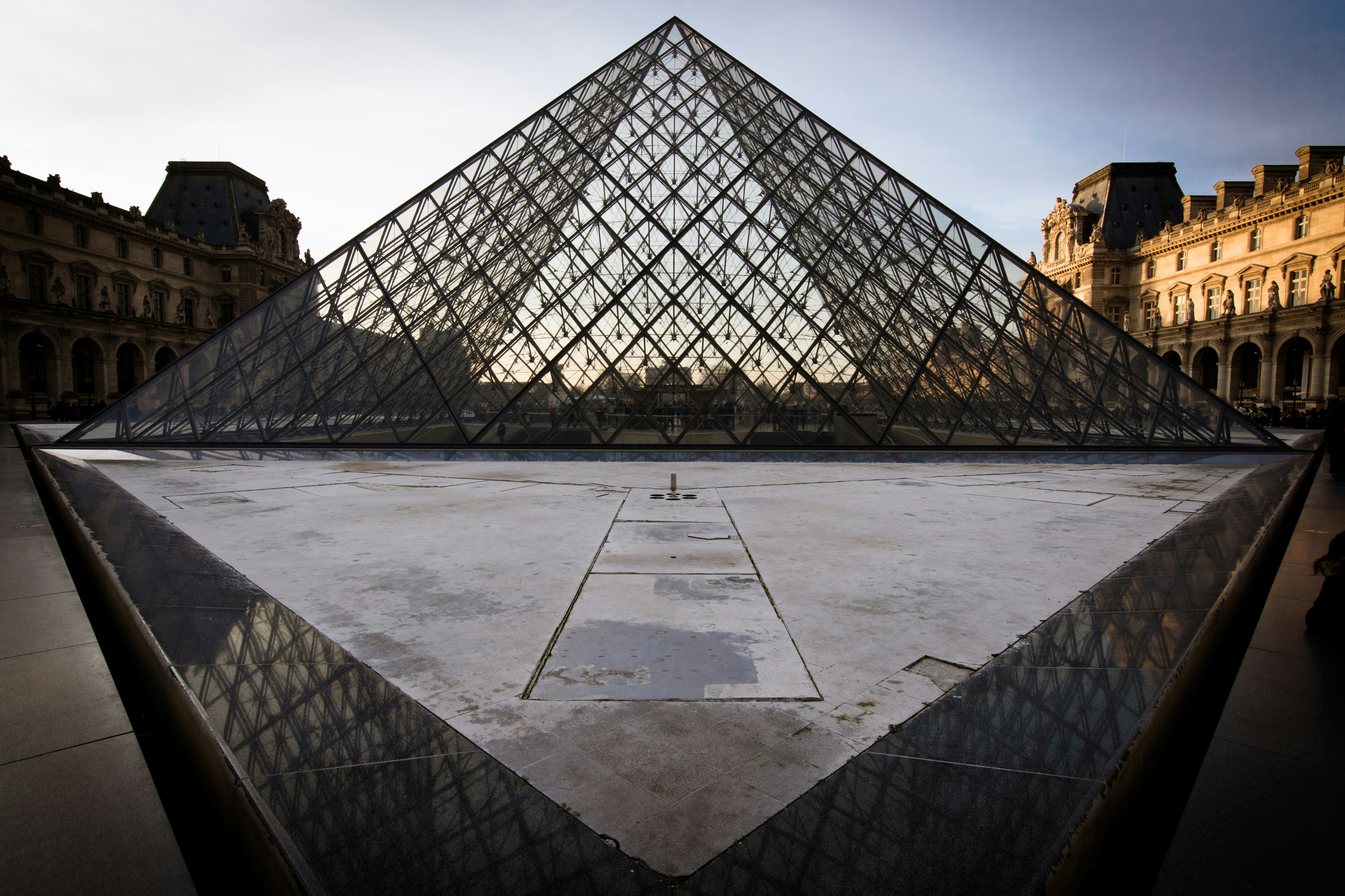 a large glass pyramid sitting in front of a building