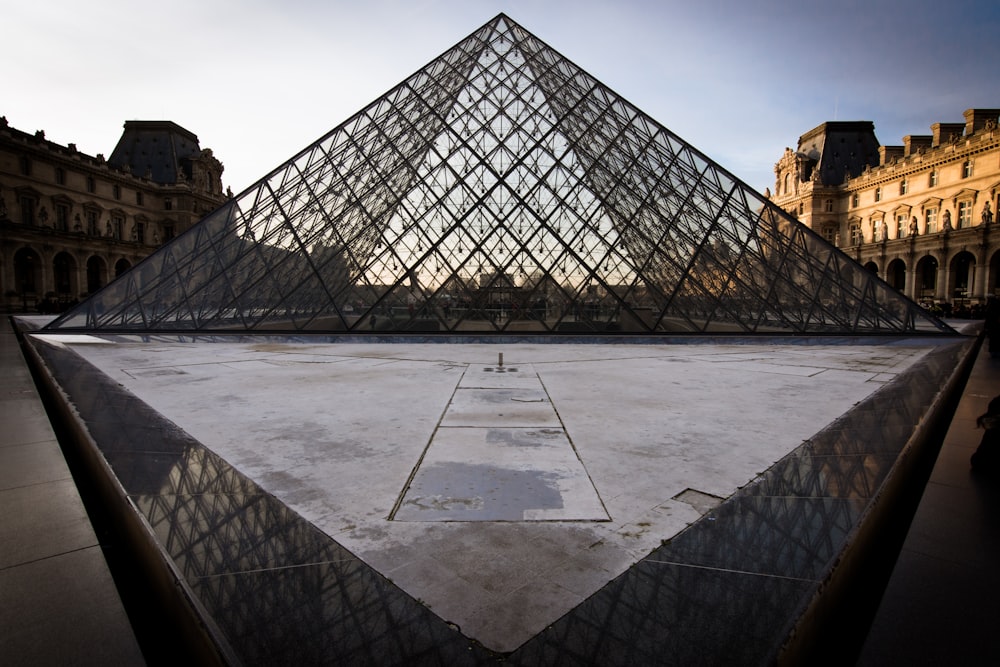 a large glass pyramid sitting in front of a building