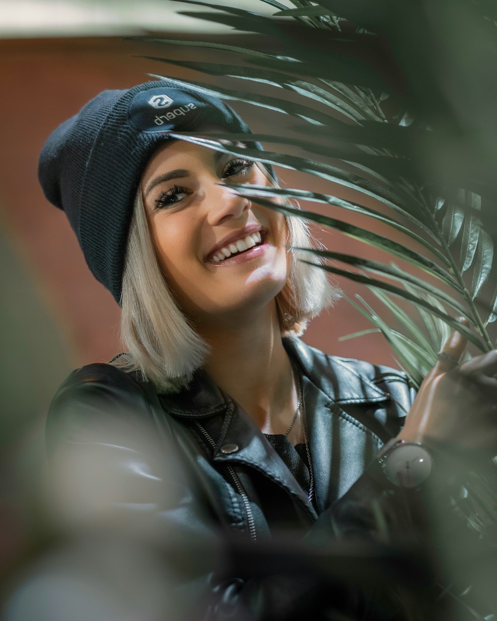 woman in black knit cap and black leather jacket