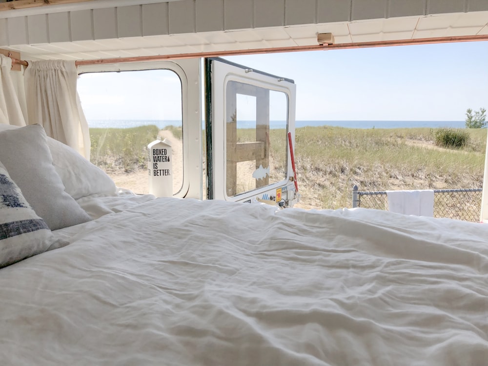 white bed linen near red metal frame