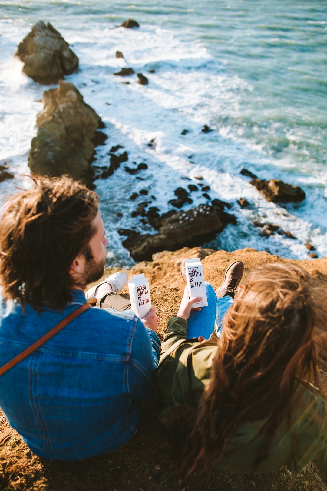 woman in blue denim jacket holding white smartphone