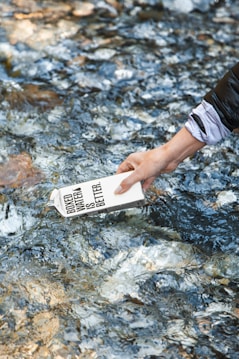 person holding white card on water