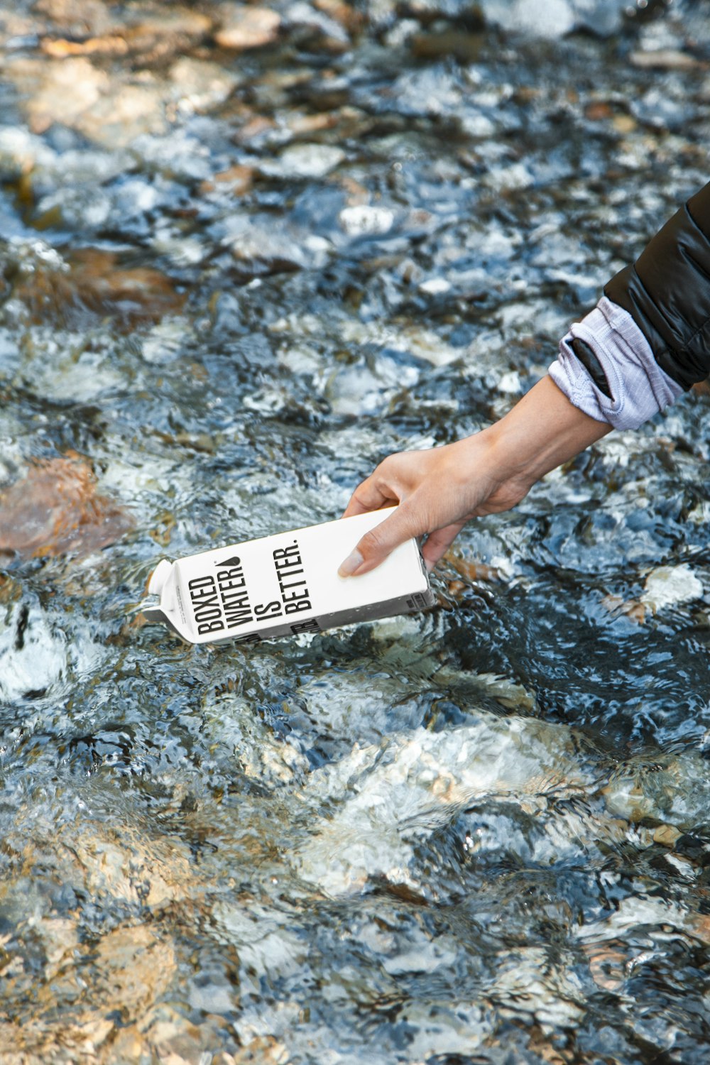person holding white card on water
