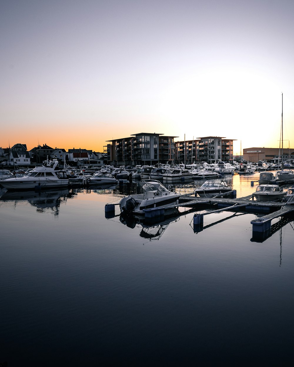 white boat on water near city buildings during sunset