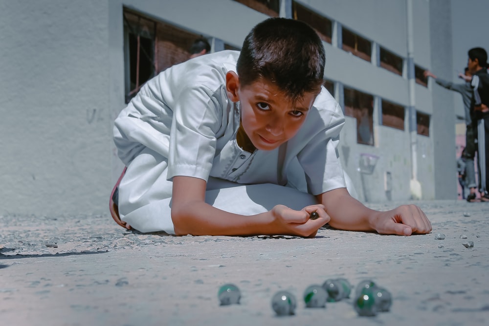 boy in white dress shirt sitting on floor