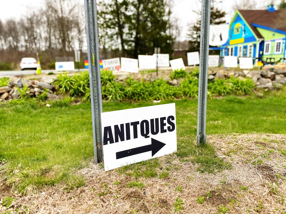 a sign pointing to the left in front of a house