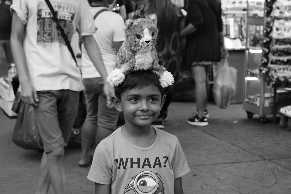 grayscale photo of girl holding bear plush toy