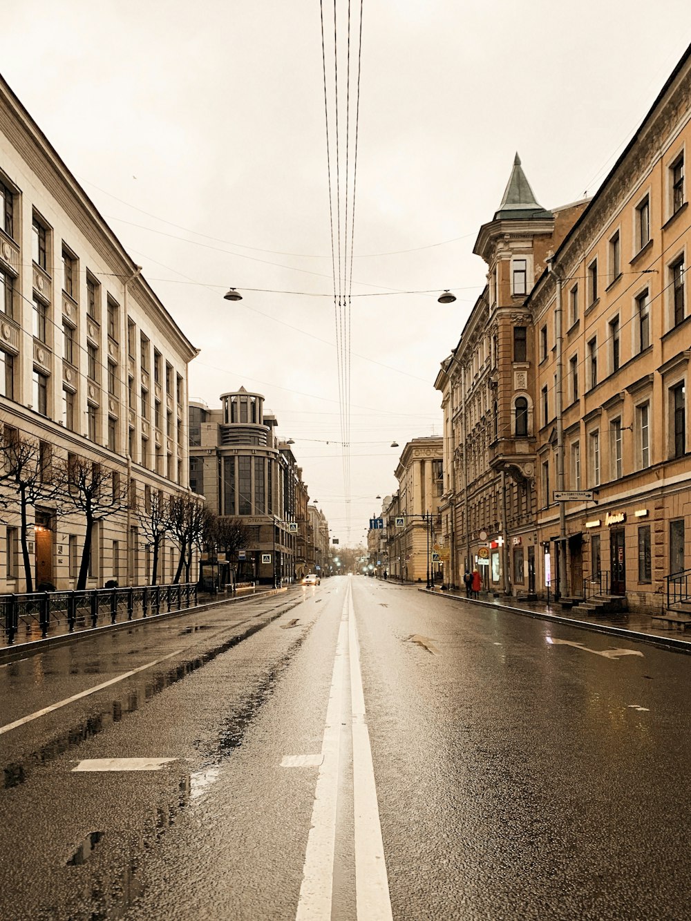 gray concrete road between brown concrete buildings during daytime