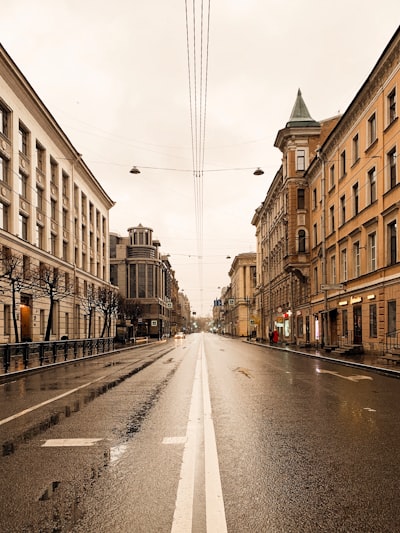 gray concrete road between brown concrete buildings during daytime